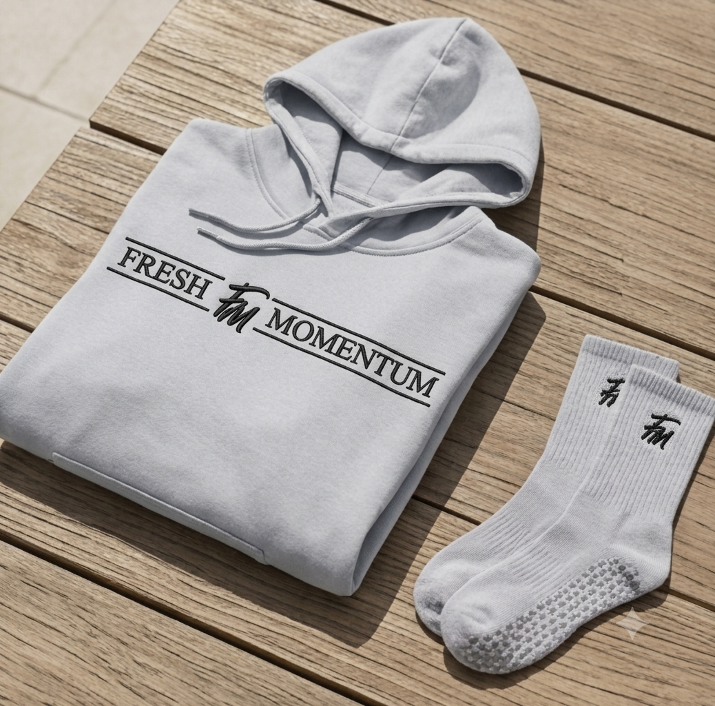 Grey Fresh Momentum wordmark hoodie folded beside FM crew socks